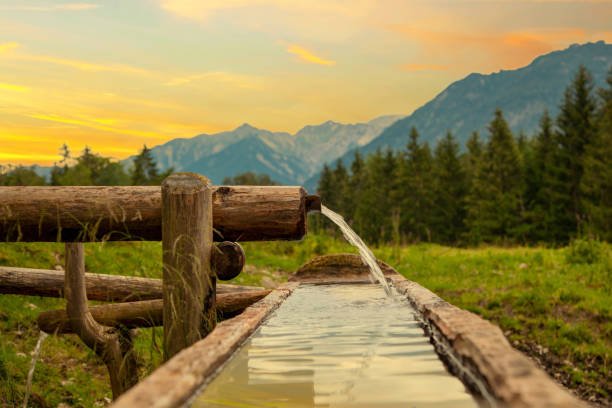 Well and Water trough made out of tree trunk in the alps. copy space for text